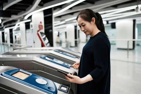 女子在現(xiàn)代地鐵站用智能手機通勤
