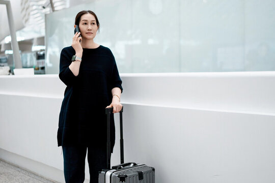 職業(yè)女性在現(xiàn)代機(jī)場(chǎng)航站樓打電話