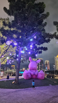 夜晚樹(shù)下的粉色萌趣大玩偶