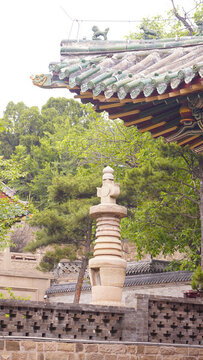古建旁的石塔與蔥郁綠樹