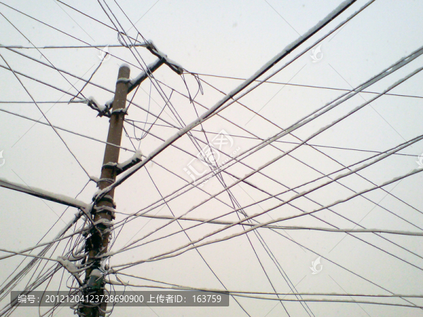 雪后掛滿積雪的電線桿和電線
