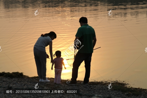 夕陽下在河邊的一家三口