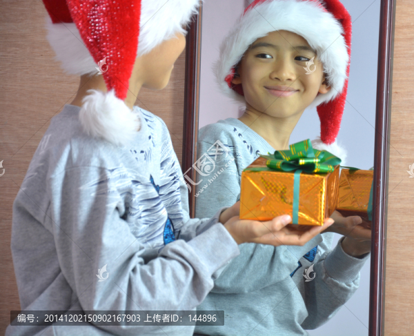 男孩捧著禮物盒照鏡子