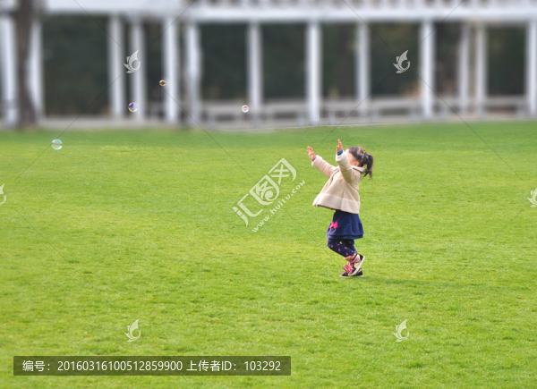 公園草坪上追逐肥皂泡的小女孩