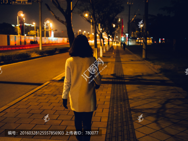 夜晚白衣少女走在人行道
