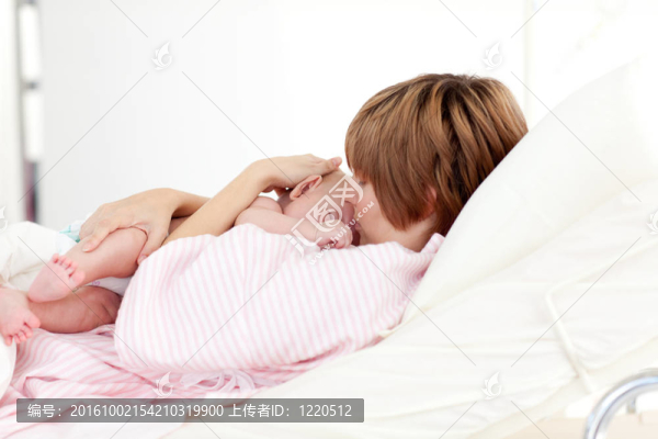 病人吻她的嬰兒在床上