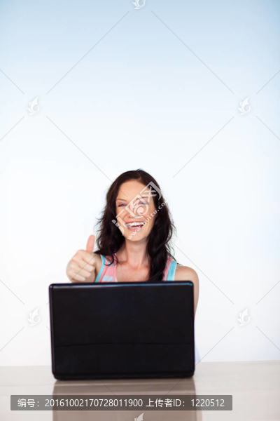 女人豎起大拇指用她的筆記本電腦