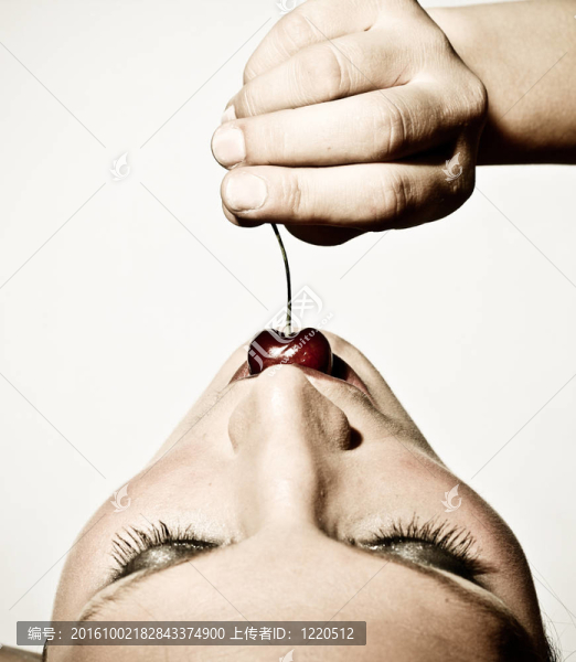 一個(gè)女人的品嘗櫻桃的特寫