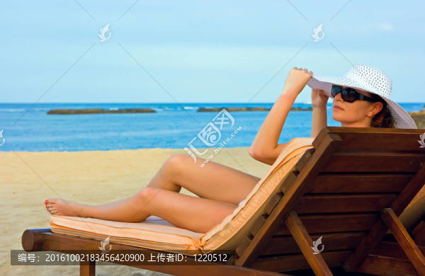 在海灘上戴著白帽子的女士