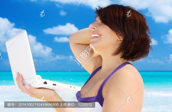 海灘上帶著筆記本電腦的女人