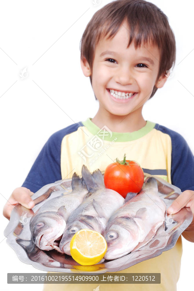 微笑的孩子在桌子上放著三條鮮魚