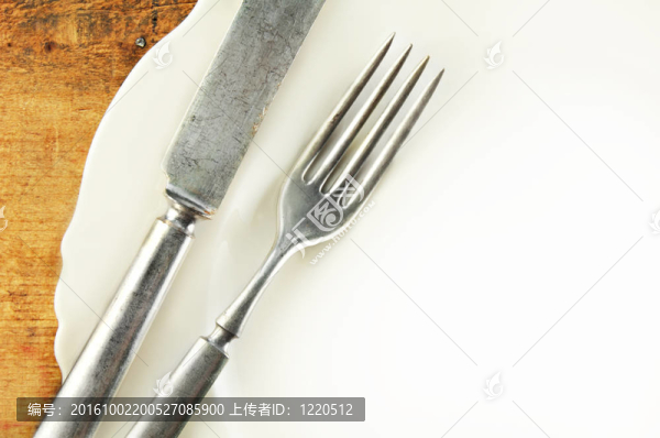 在一張木制的桌子白色的盤(pán)子和銀器