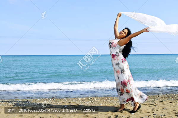 美麗的年輕女子在海灘與白色圍巾