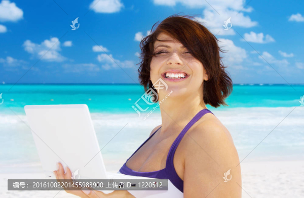 海灘上帶著筆記本電腦的女人