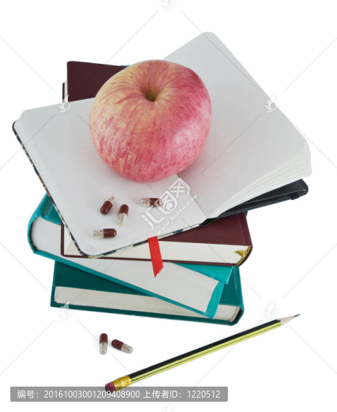 藥丸和紅蘋果在書上