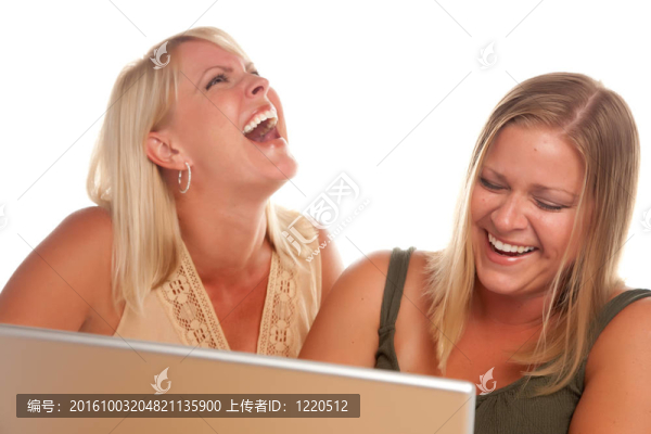 兩個笑女人使用筆記本電腦