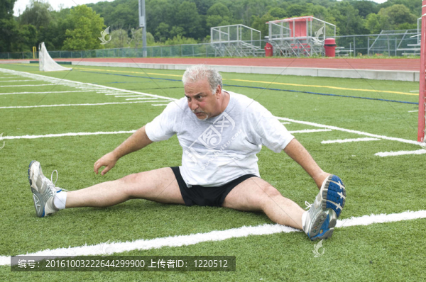 中年男子在運(yùn)動(dòng)場(chǎng)上的伸展與鍛煉