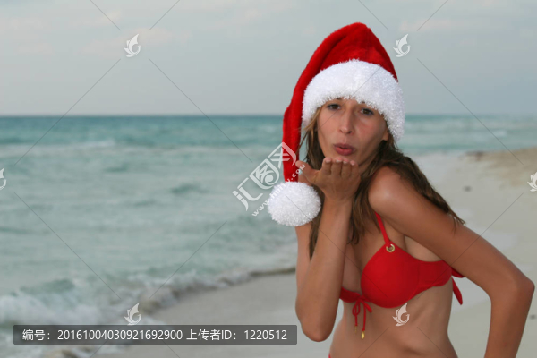 在圣誕老人帽上的海灘上打招呼