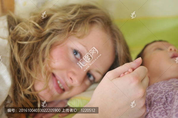 年輕漂亮母親抱著小孩子手