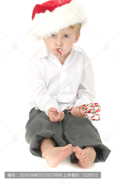 可愛的小孩戴圣誕帽吃糖果