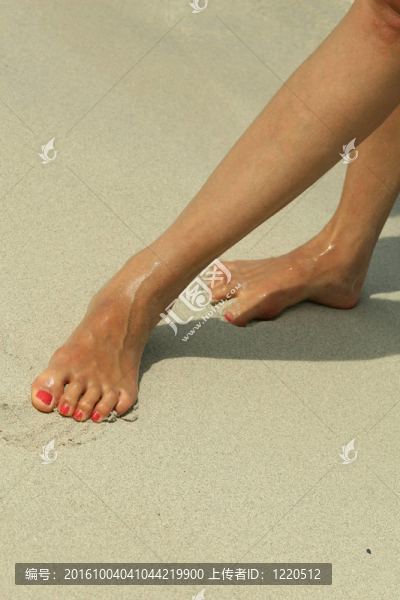 女性的腳在沙灘上