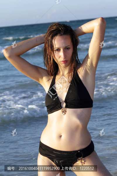 女人在Bikinis夜店的海灘上