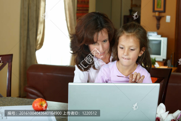 母親和女兒與筆記本電腦