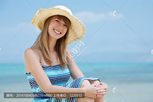 美麗的年輕女子在沙灘上微笑