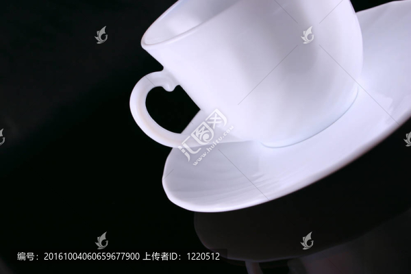 暗玻璃上有茶托的陶瓷咖啡杯