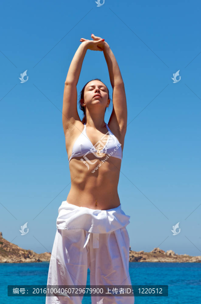 漂亮的女人和一個(gè)在撒丁島海景做放松練習(xí)；意大利