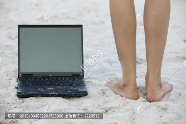 沙灘上的筆記本和腿