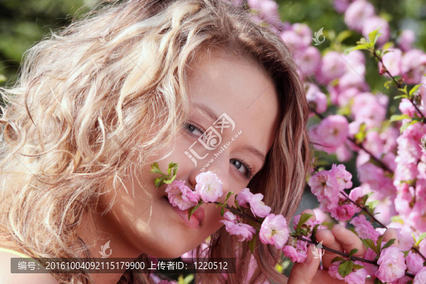 美麗的金發(fā)女人之間粉紅色的花朵