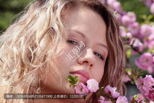 美麗的金發(fā)女人之間粉紅色的花朵