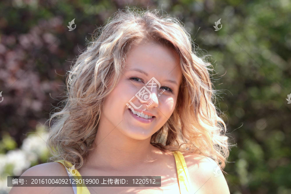 美麗的金發(fā)女人對(duì)樹與花