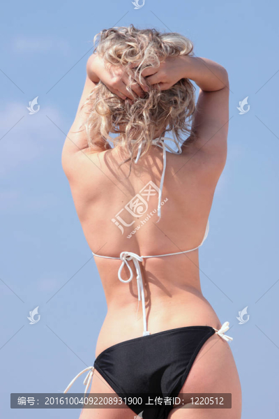 漂亮的金發(fā)女孩在比基尼曬日光浴