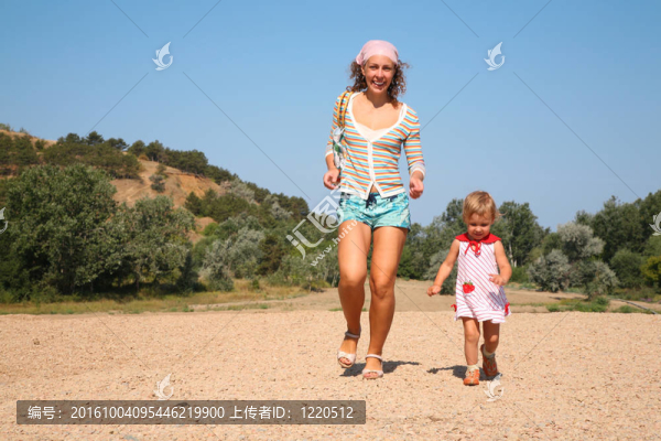 母親和女兒在海灘上跑