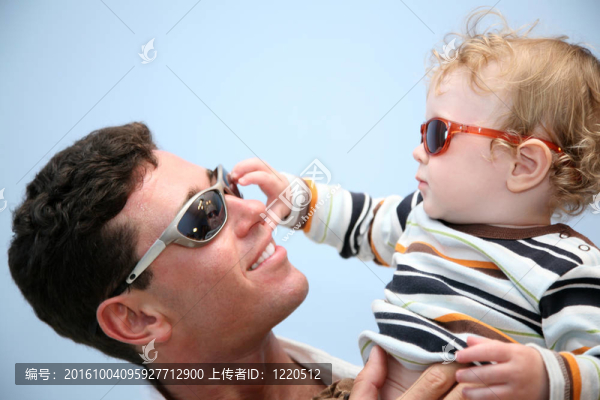 父親帶著孩子在墨鏡的背景下天空