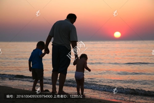 在海上日落時(shí)帶著孩子的祖父