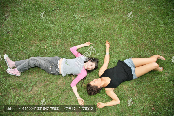 母親和女兒青少年躺在草地上