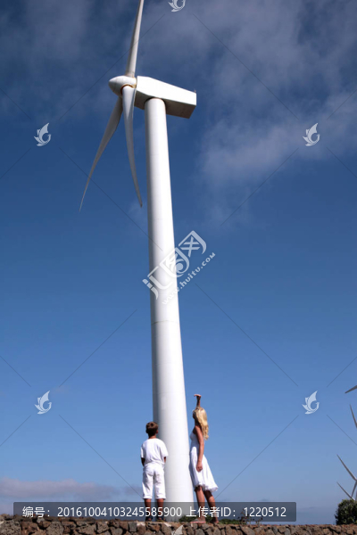 兒子和媽媽仰望一個風力渦輪機