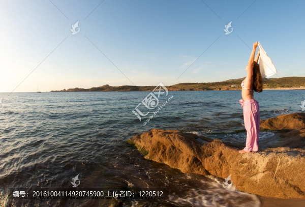 女人在巖石上放松與海景