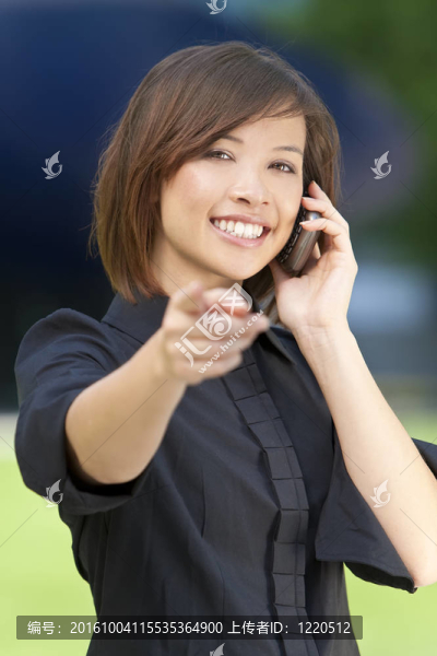 美麗的東方女子在她的智能手機(jī)和指點(diǎn)