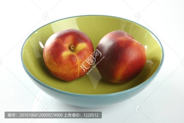 兩個紅桃子在一個綠色的盤子里
