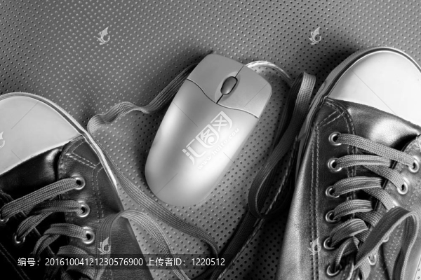 運(yùn)動(dòng)鞋之間的銀色有線電腦鼠標(biāo)