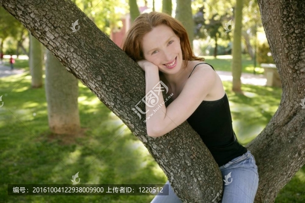 美女坐在公園樹上