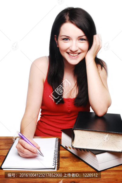 微笑的女孩在寫(xiě)字臺(tái)上寫(xiě)字