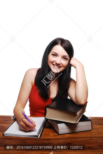 微笑的女孩在寫字臺上寫字