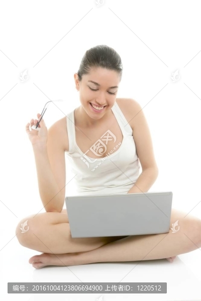 漂亮的女人在地板上與筆記本電腦