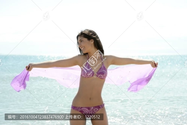 美麗的女人擺在沙灘上比基尼