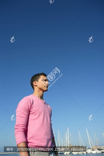 英俊的年輕人在夏天的港灣里